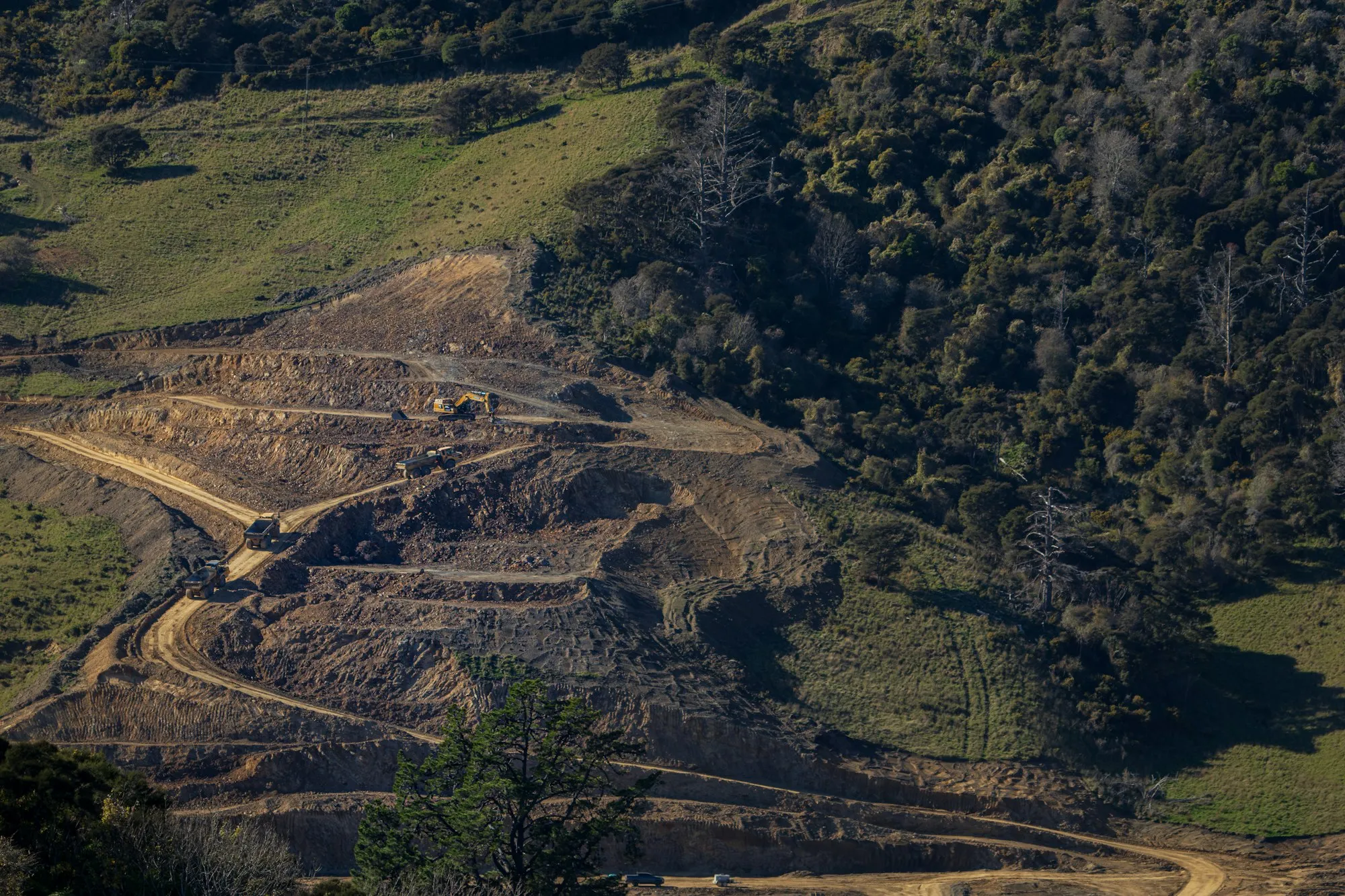 Earthmoving equipment on a terraced hillside construction site