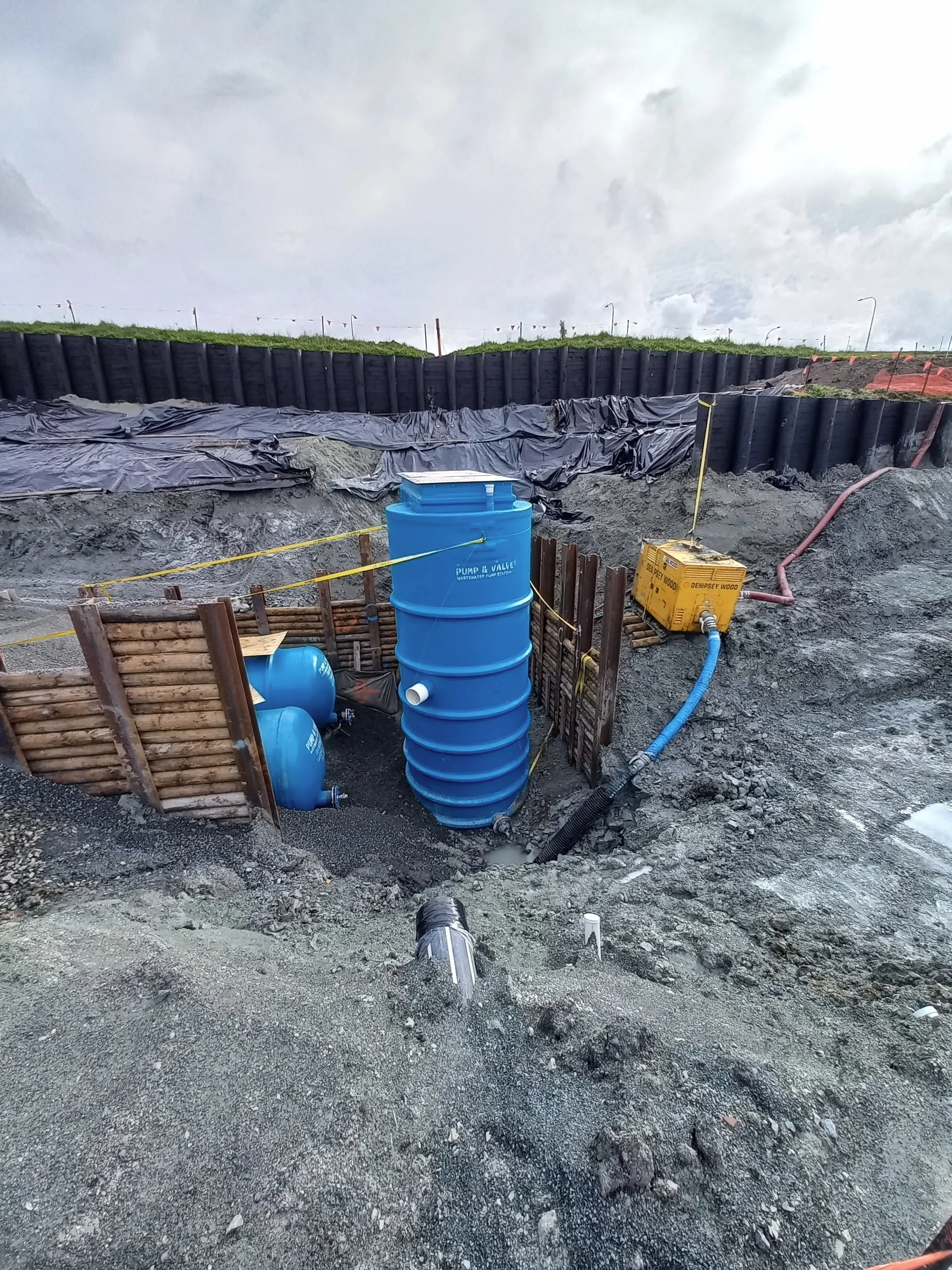 Wastewater pump station wet well and emergency storage tanks being installed in a shored excavation
